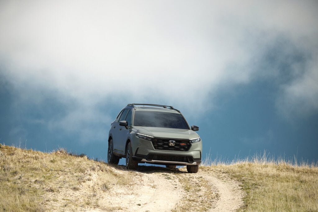 Front view of a 2026 Honda CR-V TrailSport Hybrid on a hilltop trail