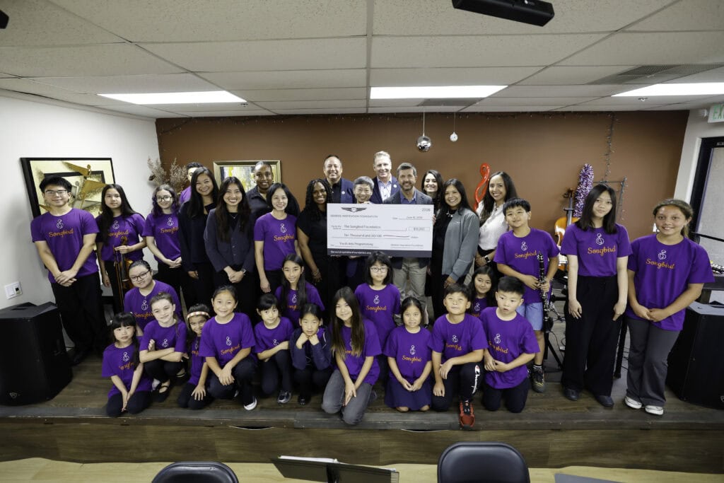 Genesis Inspiration Foundation and Songbird Music School, with a check for $10,000