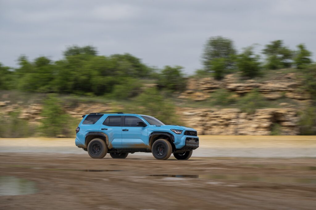 Side view of the 2026 Toyota 4Runner TRD Pro driving across a gravel clearing