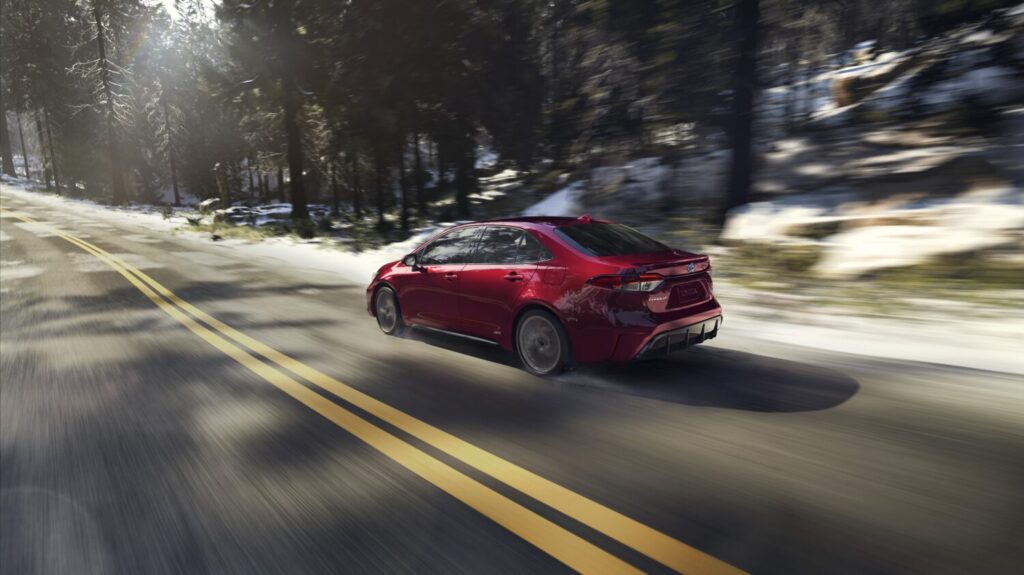 2026 Toyota Corolla hybrid speeding through snowy landscape