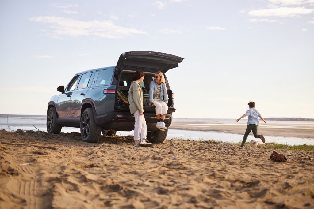 America’s Biggest Road Trip Family on the beach with a Rivian R1 S