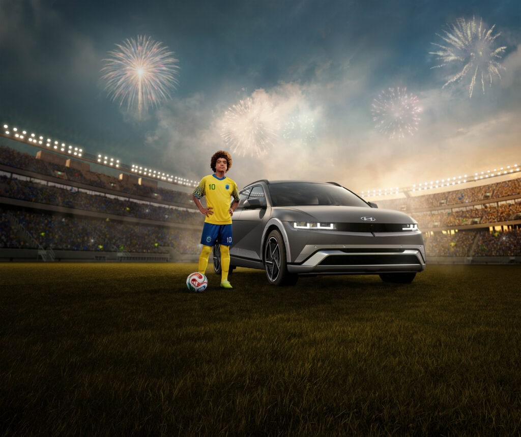 Young soccer player stands next to a Hyundai