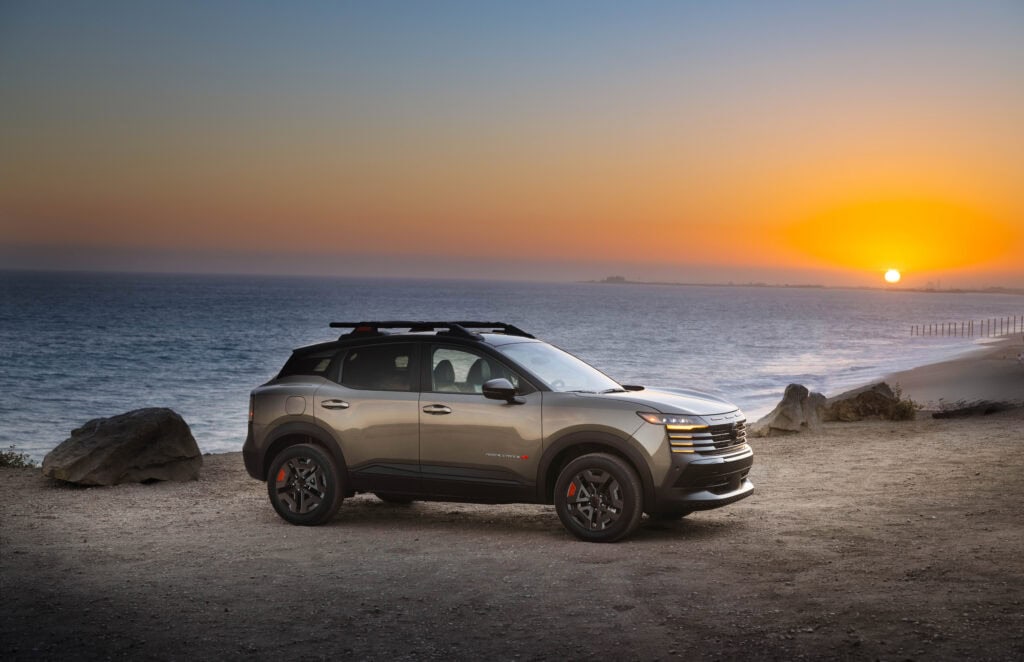 Front right 3/4 view of the 2027 Nissan Kicks Rock Creek park on a beach with the sun setting behind.