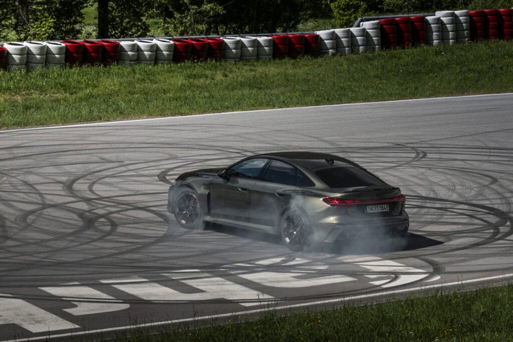 Audi RS 5 Sedan in Bedford green, outdoor driving shot, exterior, rear view during a dynamic drift.