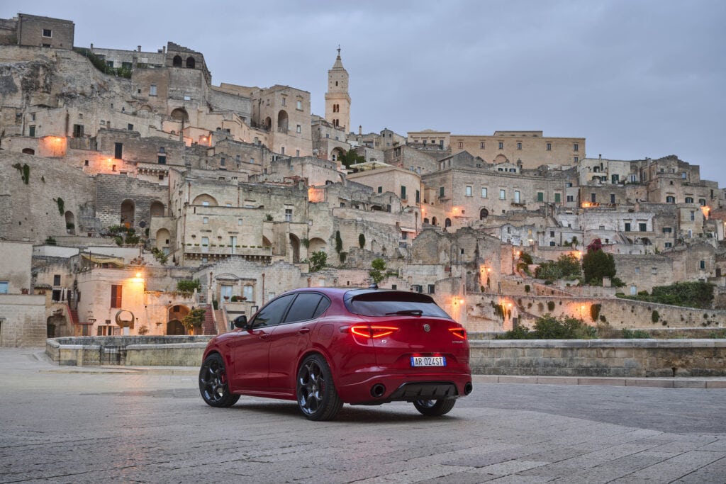 2025 Alfa Romeo Stelvio in front of Italian city in the twilight