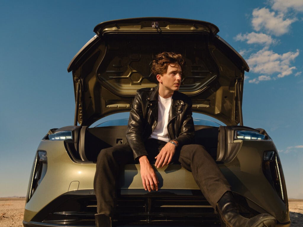 Timothée Chalamet, sitting in the front trunk of the Lucid Gravity