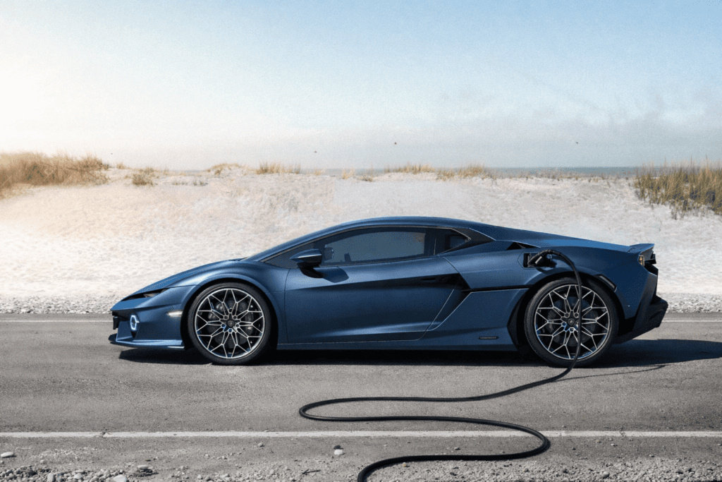 Lamborghini Temerario plugged into power on a road next to sand dunes.