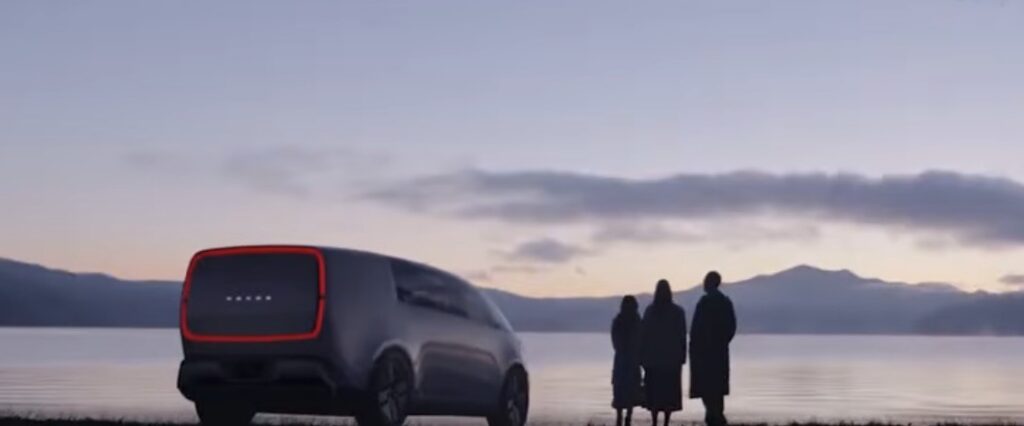 Honda futuristic electric vehicle concept parked by a lake at sunset, showing a family silhouette and AI-powered future transportation design.