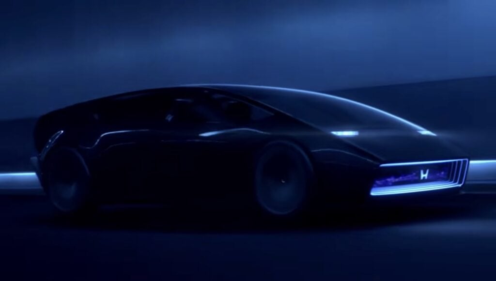 Honda futuristic AI concept car driving in blue light, showing an advanced electric vehicle design for the future of mobility.