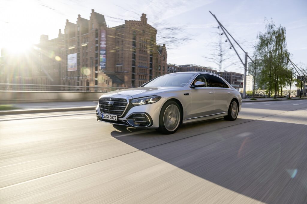 Silver Mercedes-Benz S-Class driving along a city street.