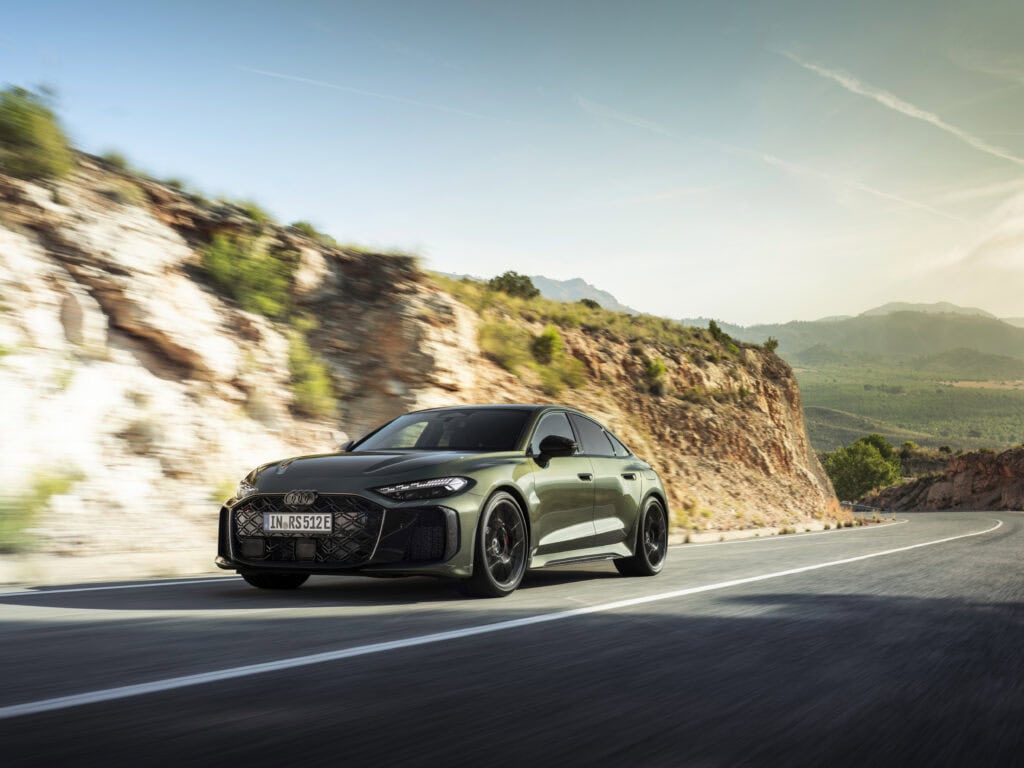 2027 Audi RS 5 Sedan driving on a mountain road during sunset