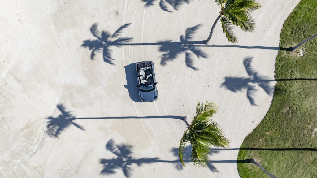 Mini convertible on the beach, pictured with the top down in a blue Color