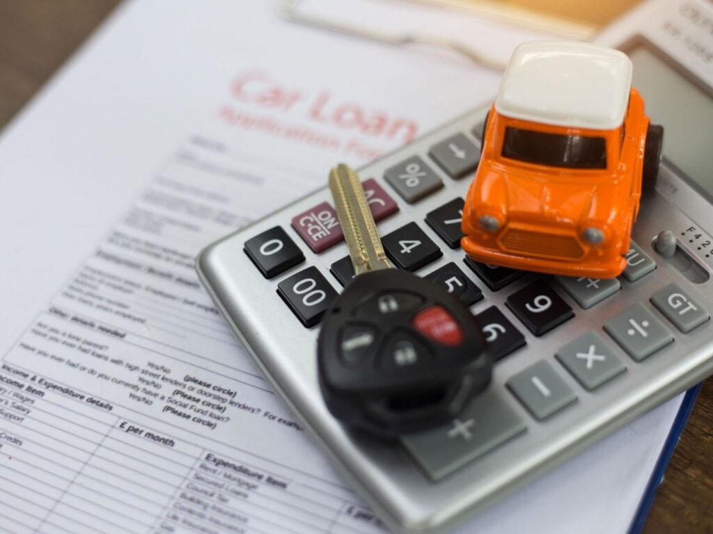 Car keys and a calculator sitting on the desk of an auto loan specialist