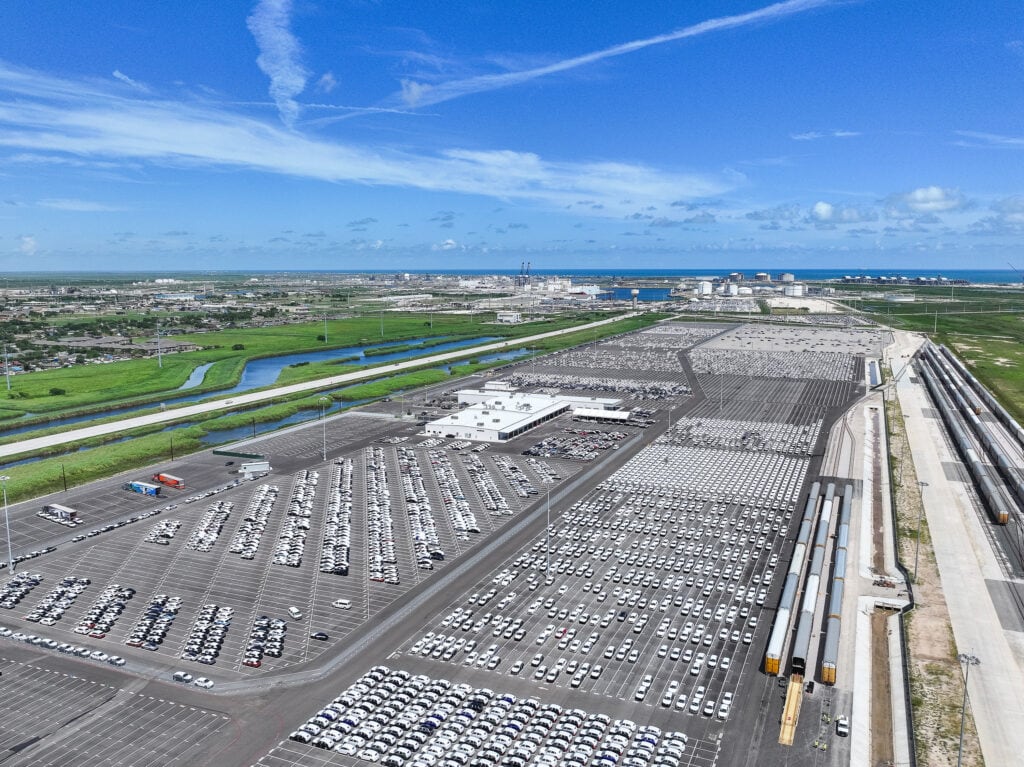 An overhead view of a large Volkswagen factory showing buldings and vehicles parked outside