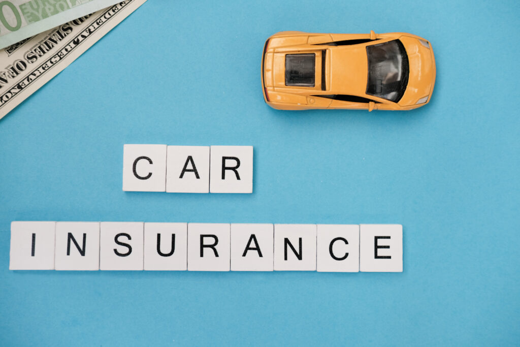 Wooden blocks with words car Insurance. rental business, property. Protection and Security Concept. yellow toy car and banknotes on trendy blue background
